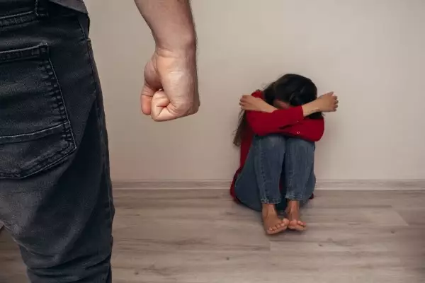 frighted-girl-red-shirt-against-wall-man-with-fists-clutched