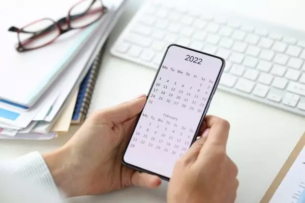 person-holding-phone-with-calendar-2022-closeup